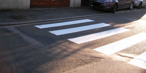 Un passage piétons devant une sortie de garage